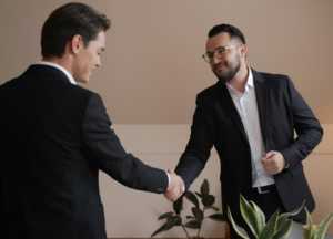 Male companion and escort shaking hands wih another men